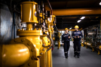Oil and gas refinery production. Factory workers in safety equip