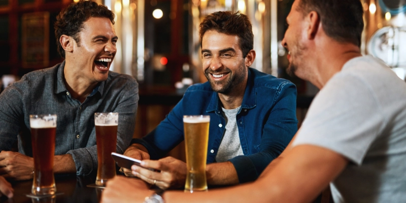 3 men at the pub happy and smiling with a pint