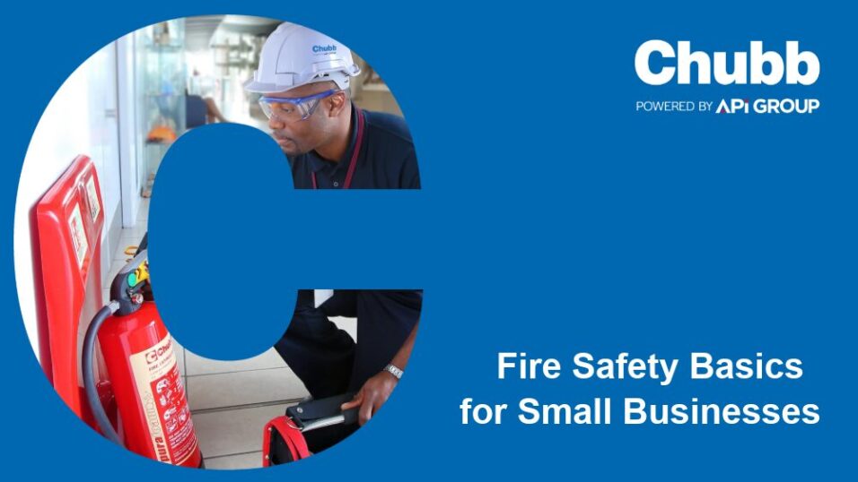 A person wearing a white Chubb hard hat and dark uniform inspects a red fire extinguisher mounted on a wall. The scene is framed within a large blue letter “C.” To the right, text reads “Chubb — Powered by API Group — Fire Safety Basics for Small Businesses” on a blue background.