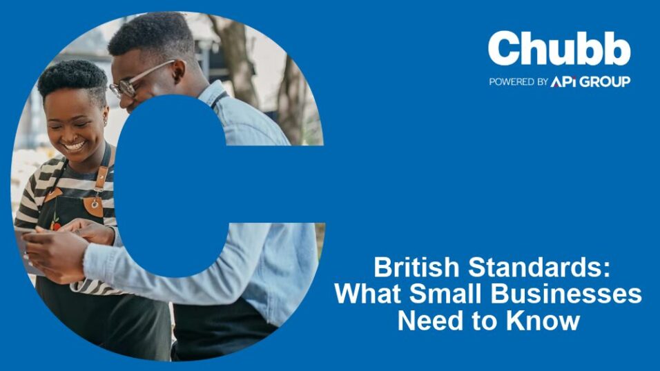 Two small business owners stand together smiling at a smartphone, framed by a large blue “C”, alongside Chubb branding and the headline “British Standards: What Small Businesses Need to Know”, promoting SME fire‑safety guidance and compliance support.